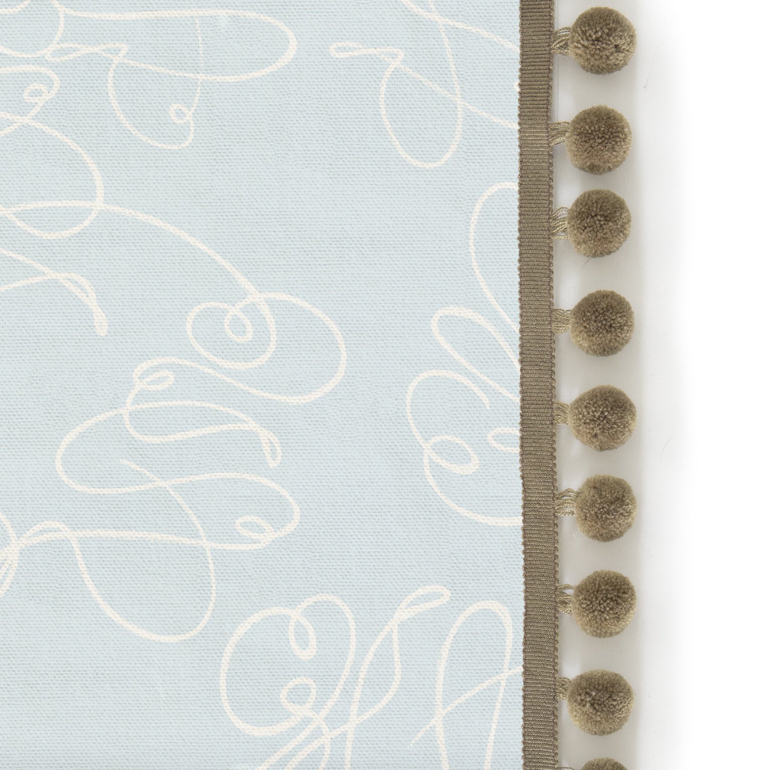 Upclose picture of Mirabella custom Powder Blue Abstractshower curtain with olive pom pom trim