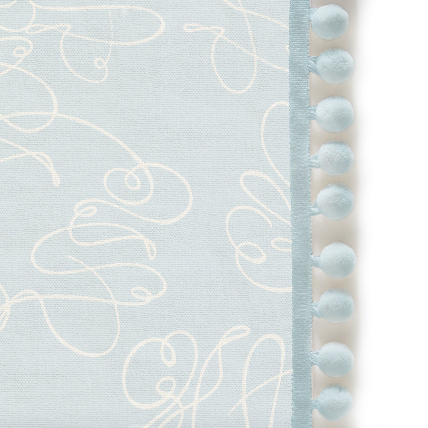 Upclose picture of Mirabella custom Powder Blue Abstractshower curtain with powder pom pom trim