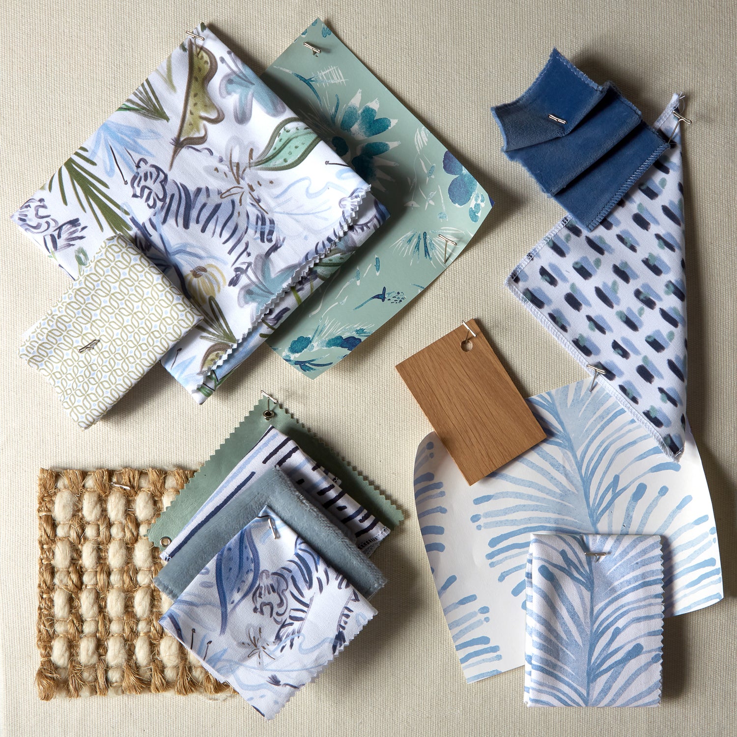 Moodboard featuring blue and green printed fabrics and a neutral rug sample.