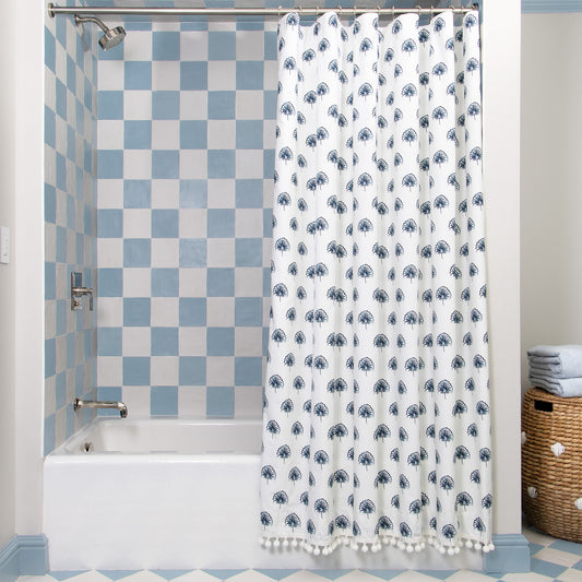 Floral Navy Printed shower curtain hanging on rod in front of white tub in bathroom with blue and white tiles
