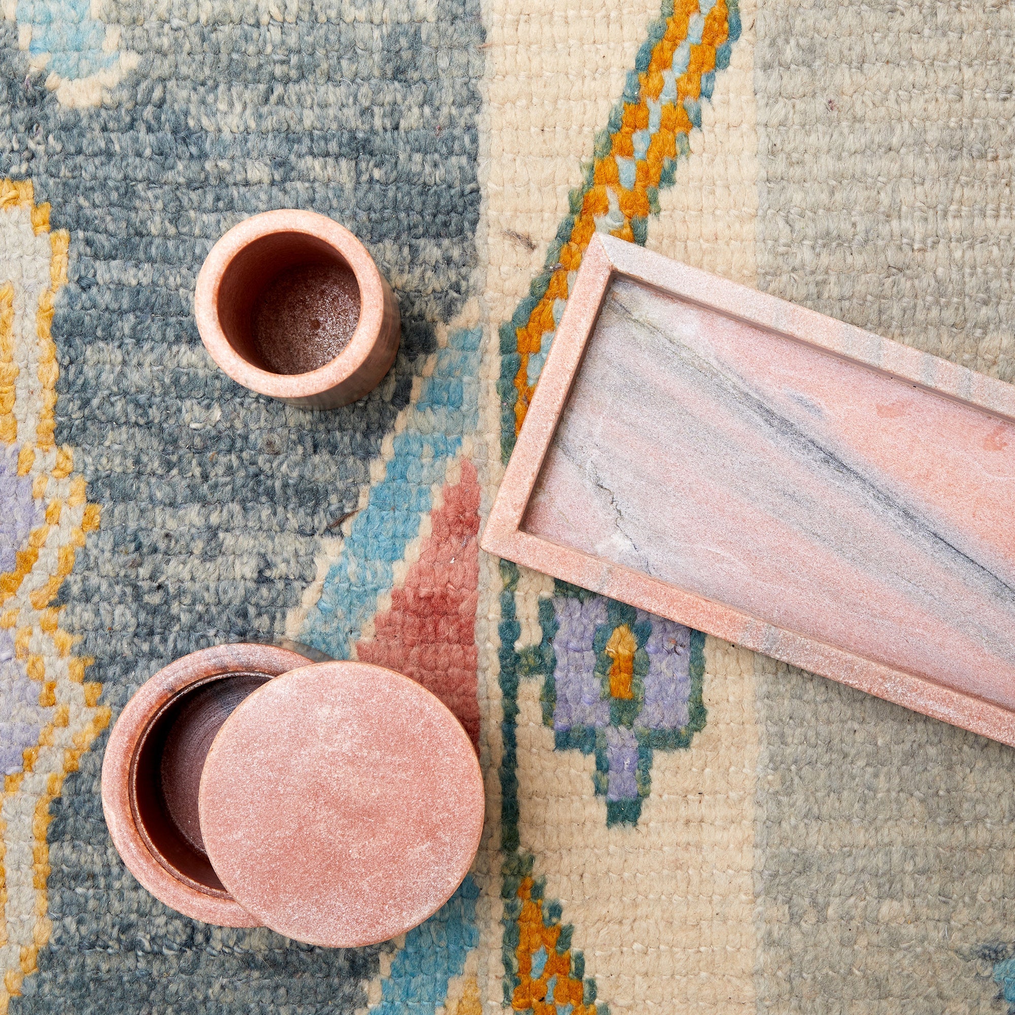 over head picture of pink marble tumbler, tray, and cotton jar 