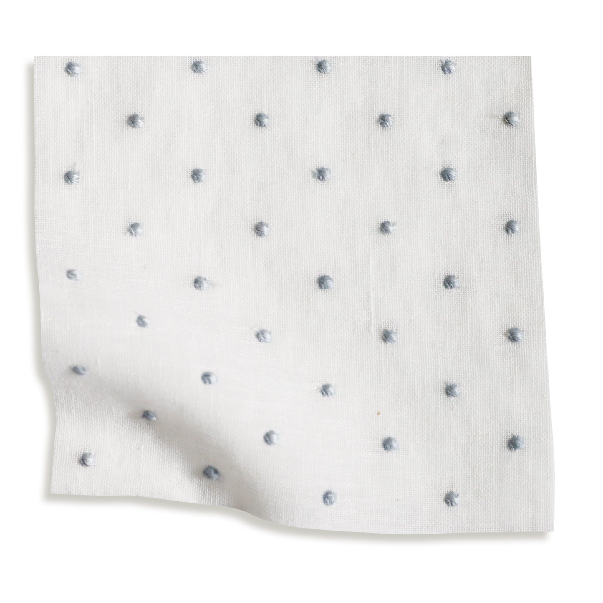 sheer white  fabric swatch with embroidered blue polka dots on it 