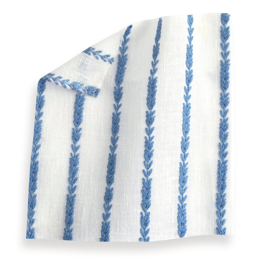 sheer white fabric swatch with embroidered cobalt blue stripes on it 