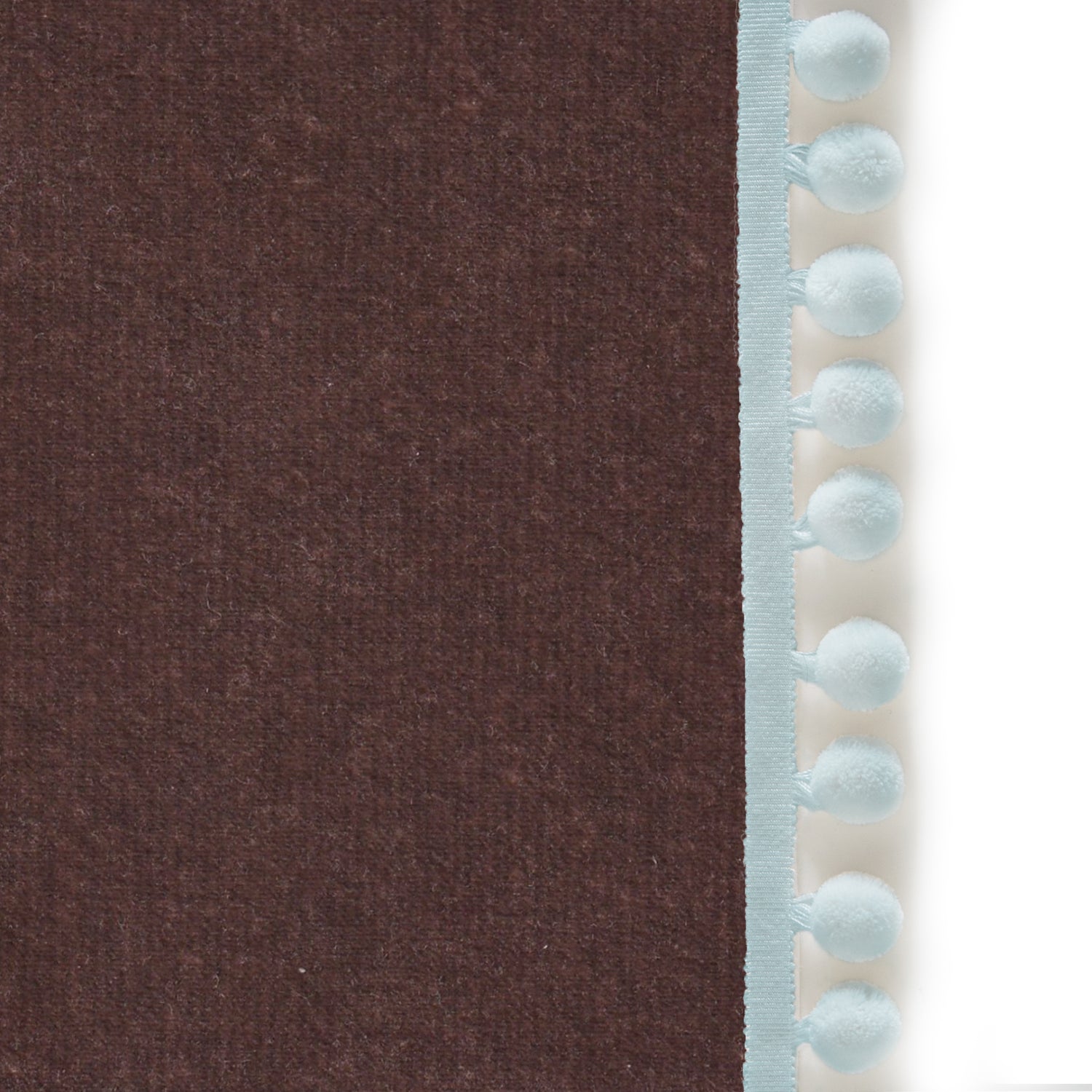 Upclose picture of Walnut Velvet custom curtain with powder pom pom trim