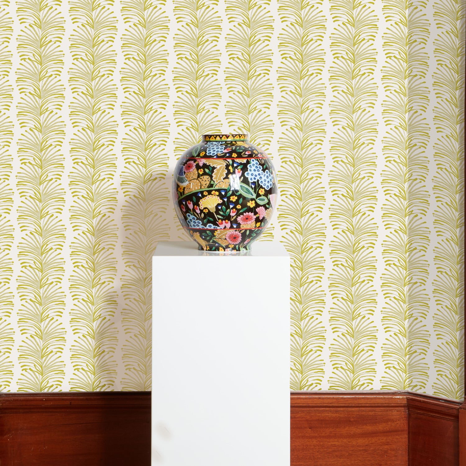 Yellow Stripe Chartreuse Printed Wallpaper with a black floral vase on a white squared stand