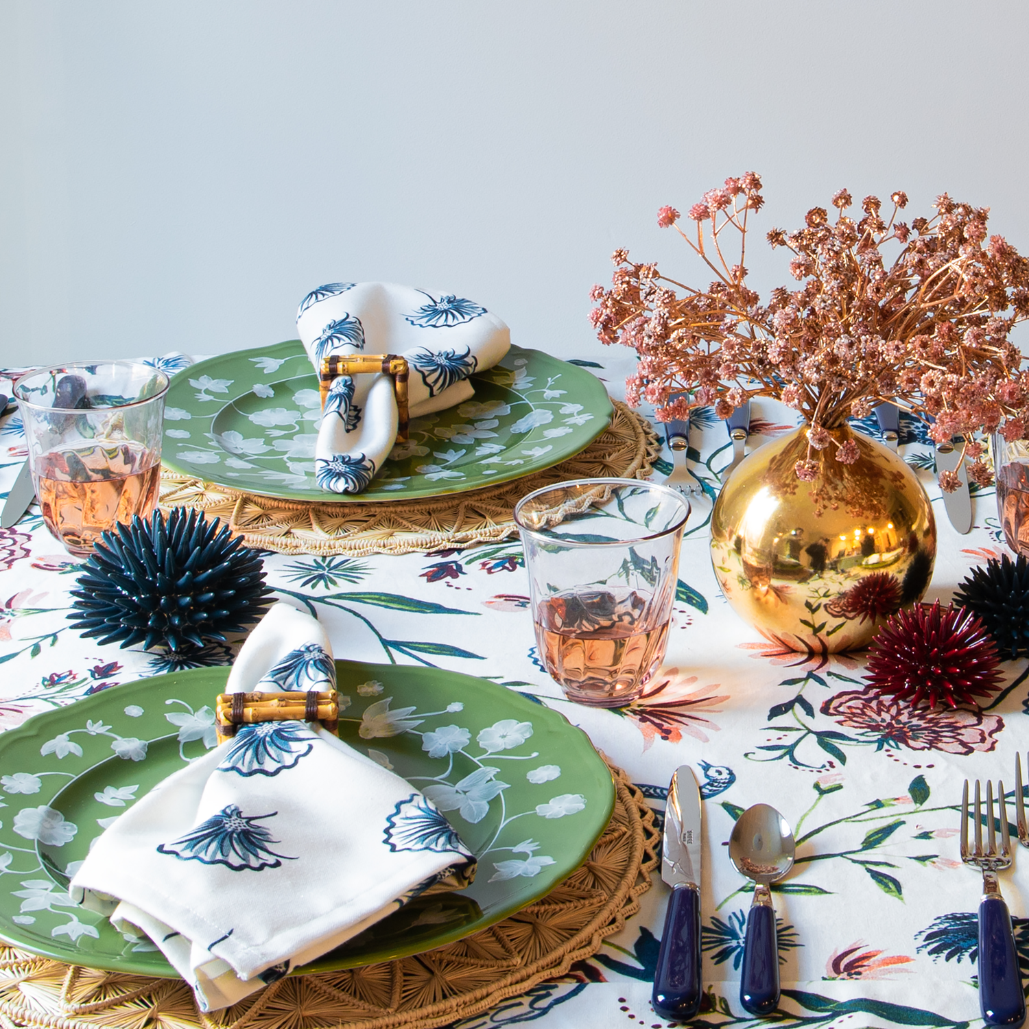 Table setting Close-Up with Floral Navy Table Cloth Napkin on plate styled with pink roses in a circular gold vase