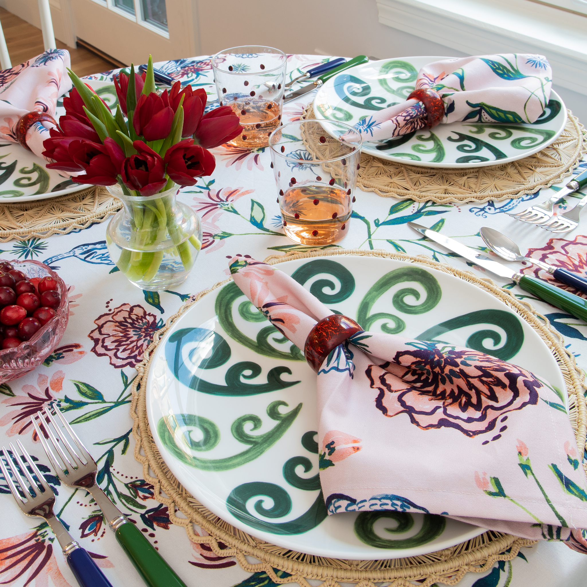 Table setting Close-Up with Rose Chinoiserie Table Cloth Napkin on plate styled with red roses in a transparent vase