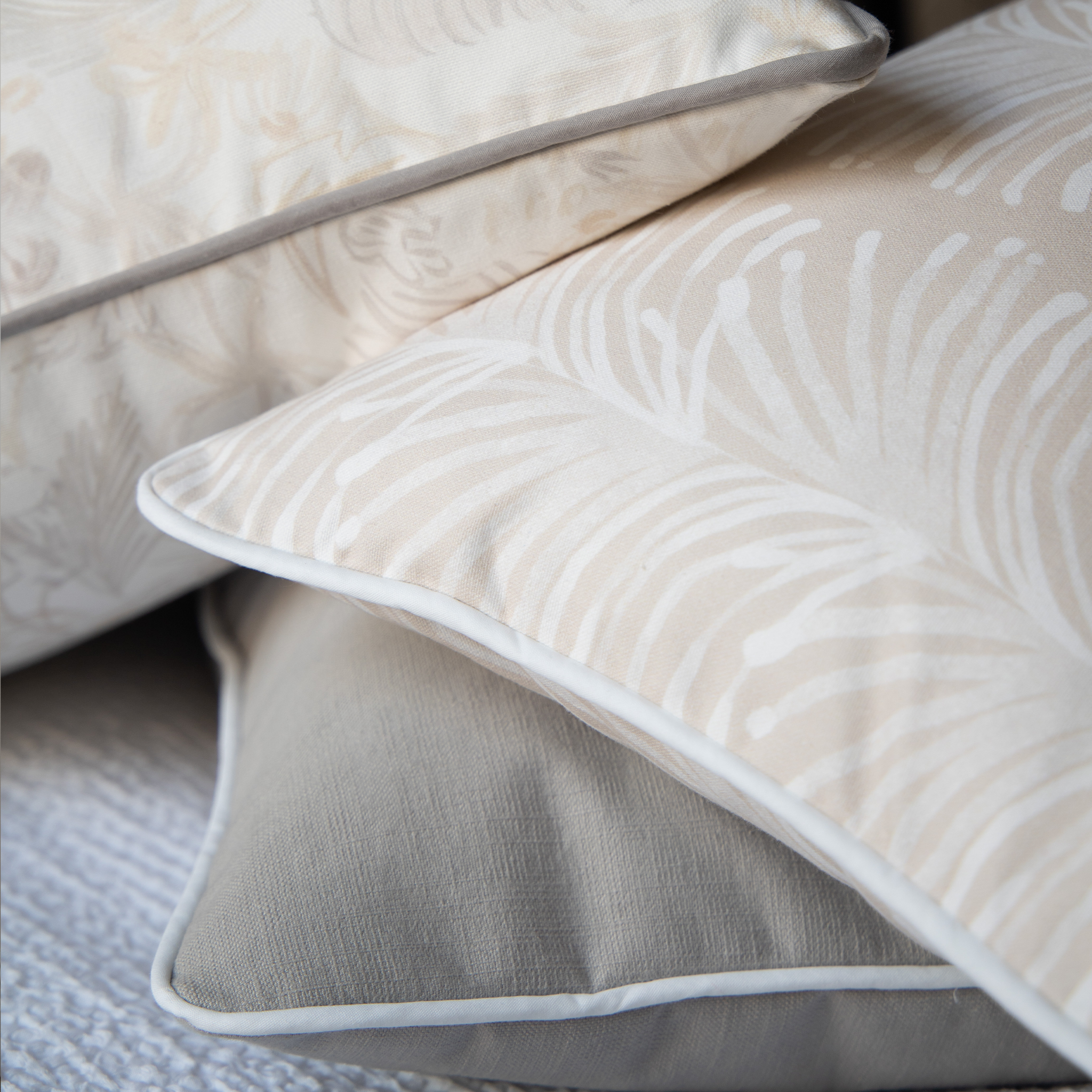 Close-Up of Beige Chinoiserie Tiger Printed Pillow, Light Brown Pillow, and Beige Botanical Stripe Printed Pillow