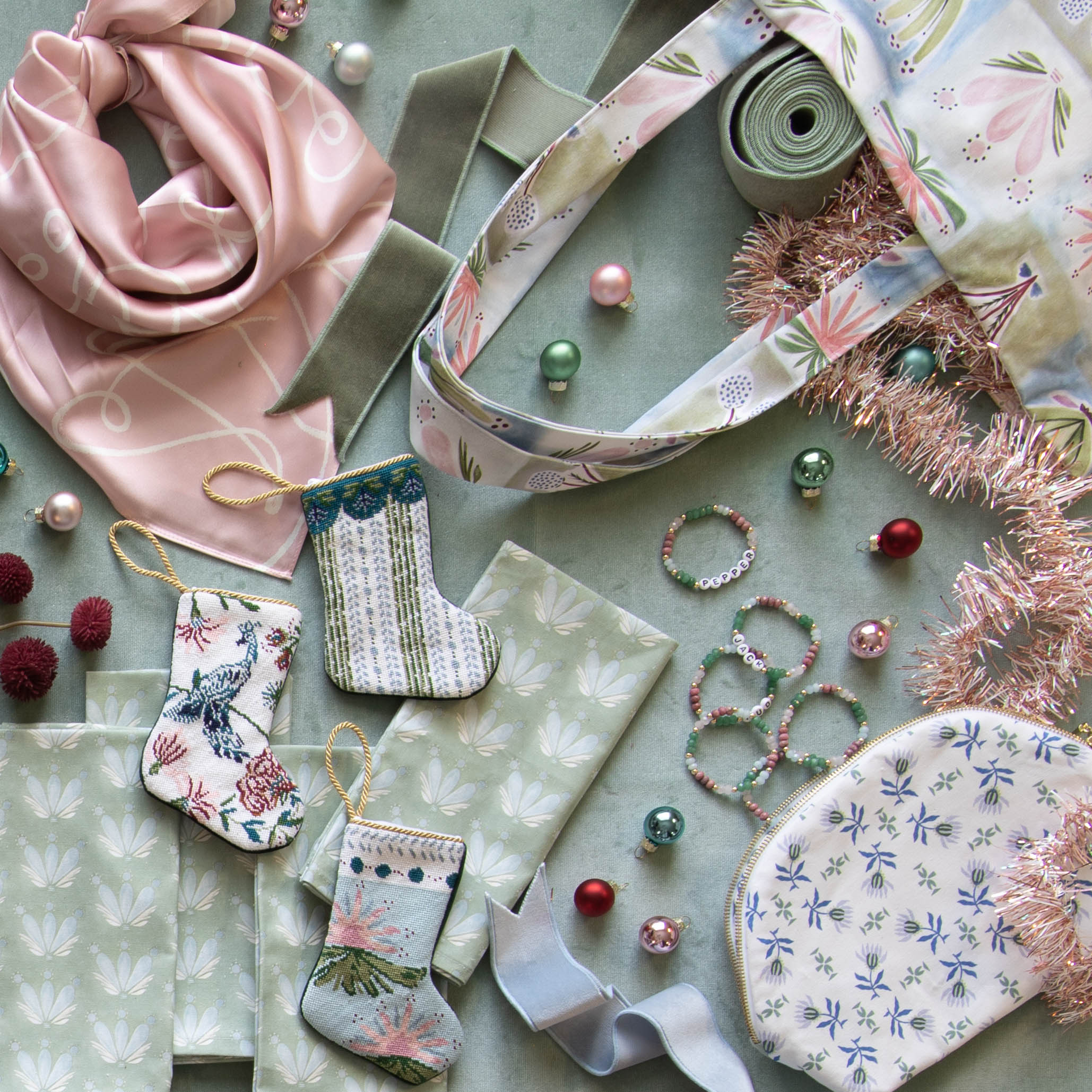 Interior design moodboard and fabric inspirations with Blue & Green Floral Drop Repeat printed cotton swatch next to three hand sown mini bauble stockings and small Christmas ornaments
