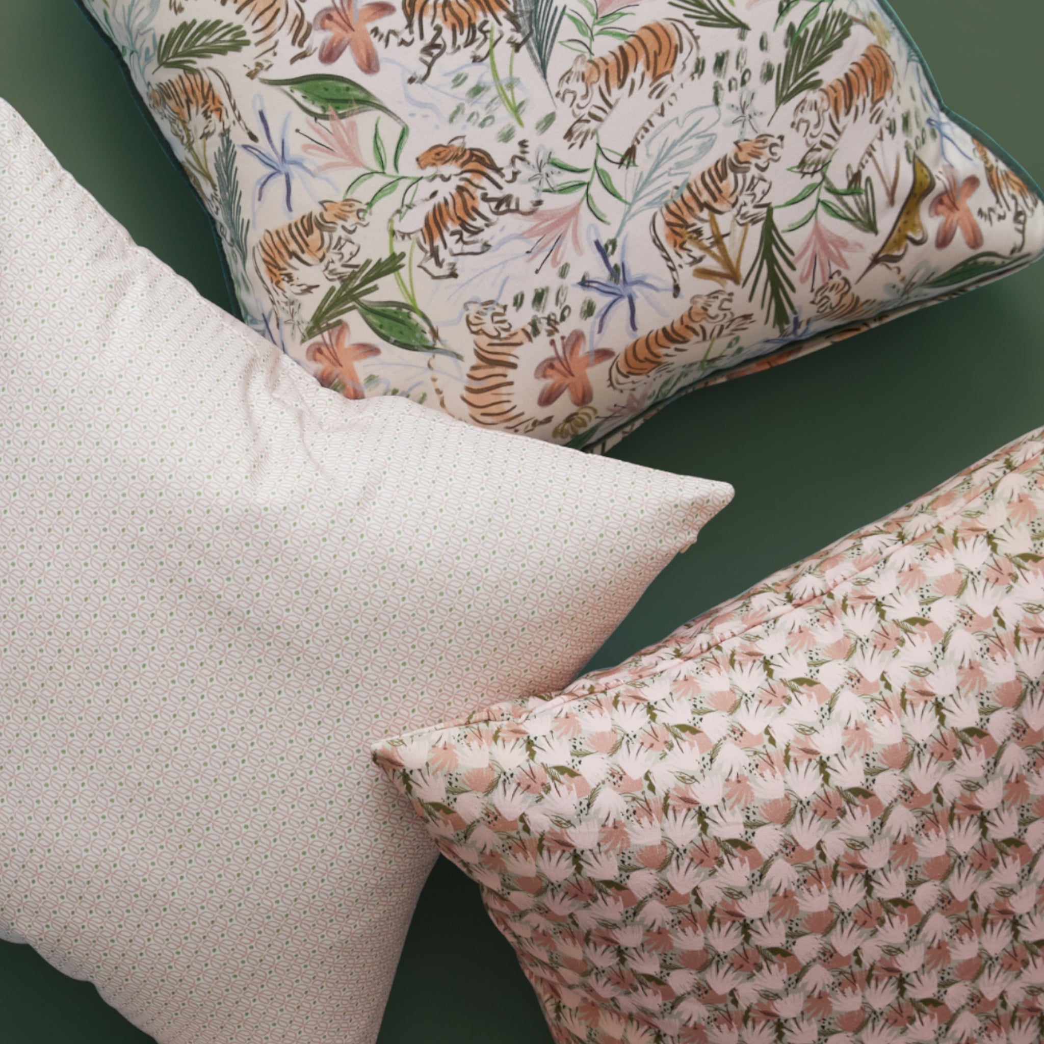 Close-up of Pink Geometric Printed Pillow, Pink Chinoiserie Printed Pillow, and Pink Floral Printed Pillow on fern green background