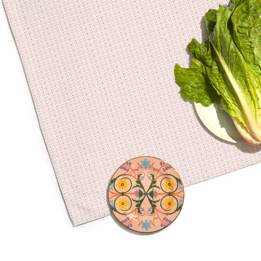 Close-up of Pink Geometric Printed Tablecloth with one plate on corner and the other besides with lettuce on top