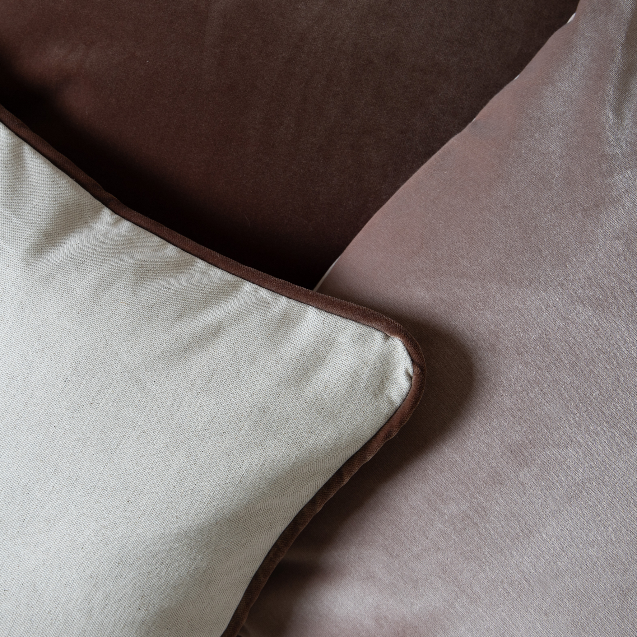 Close-up of Light Brown Linen Pillow, Mauve Velvet Pillow, and Brown Velvet Pillow