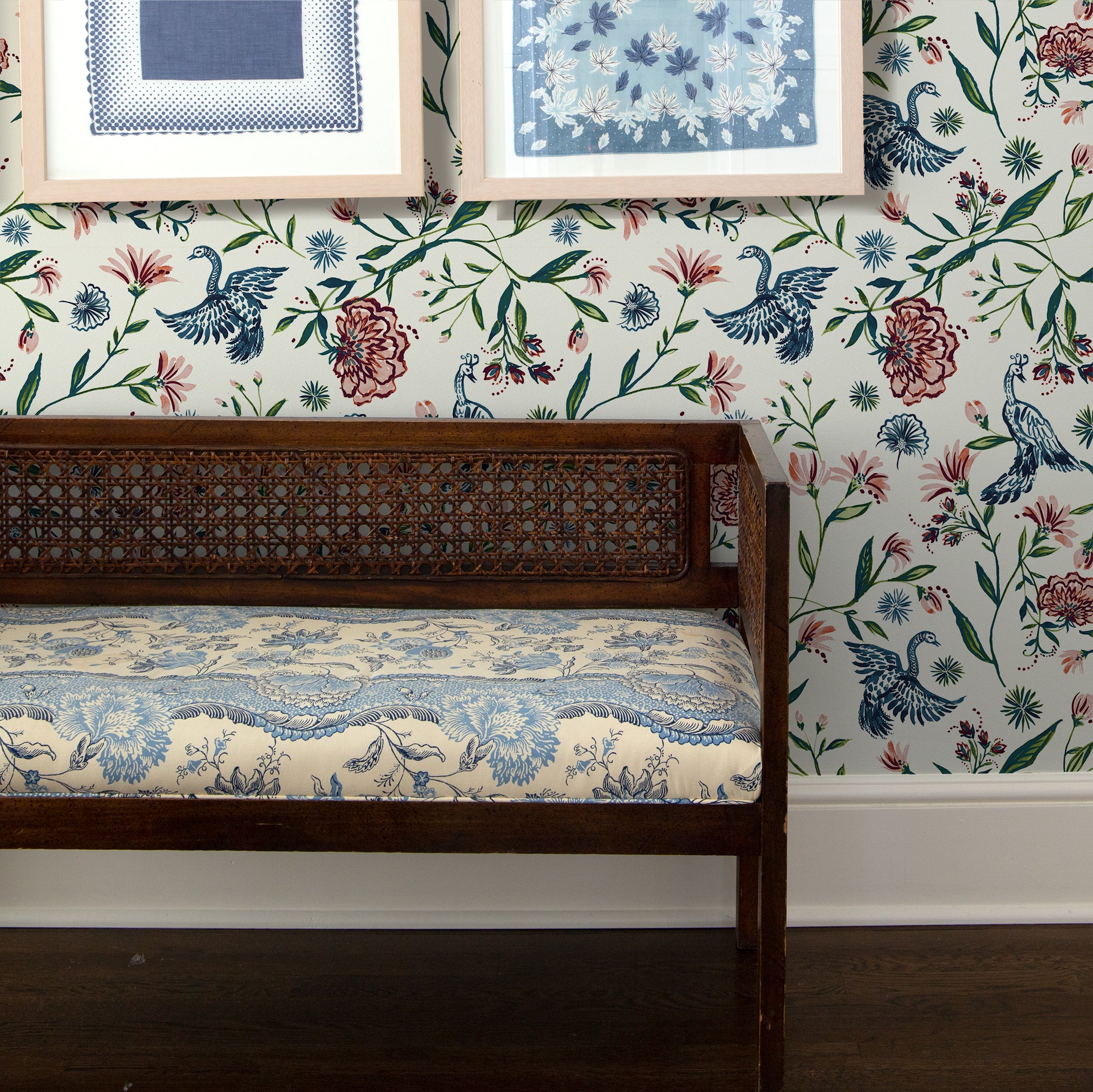 Cream Chinoiserie Wallpaper behind a long wooden chair with two frames hanging on top 