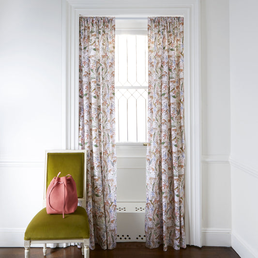 Pink Chinoiserie Tiger Printed Curtains on white rod in front of an illuminated window with Green Velvet chair with coral bag on top