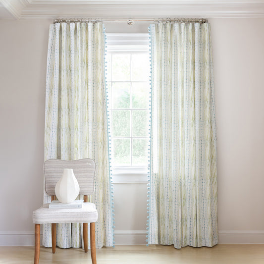 Blue & Green Striped Printed Curtains on metal rod in front of an illuminated window with Sky Blue Velvet chair with grapes in bowl on top of stacked books