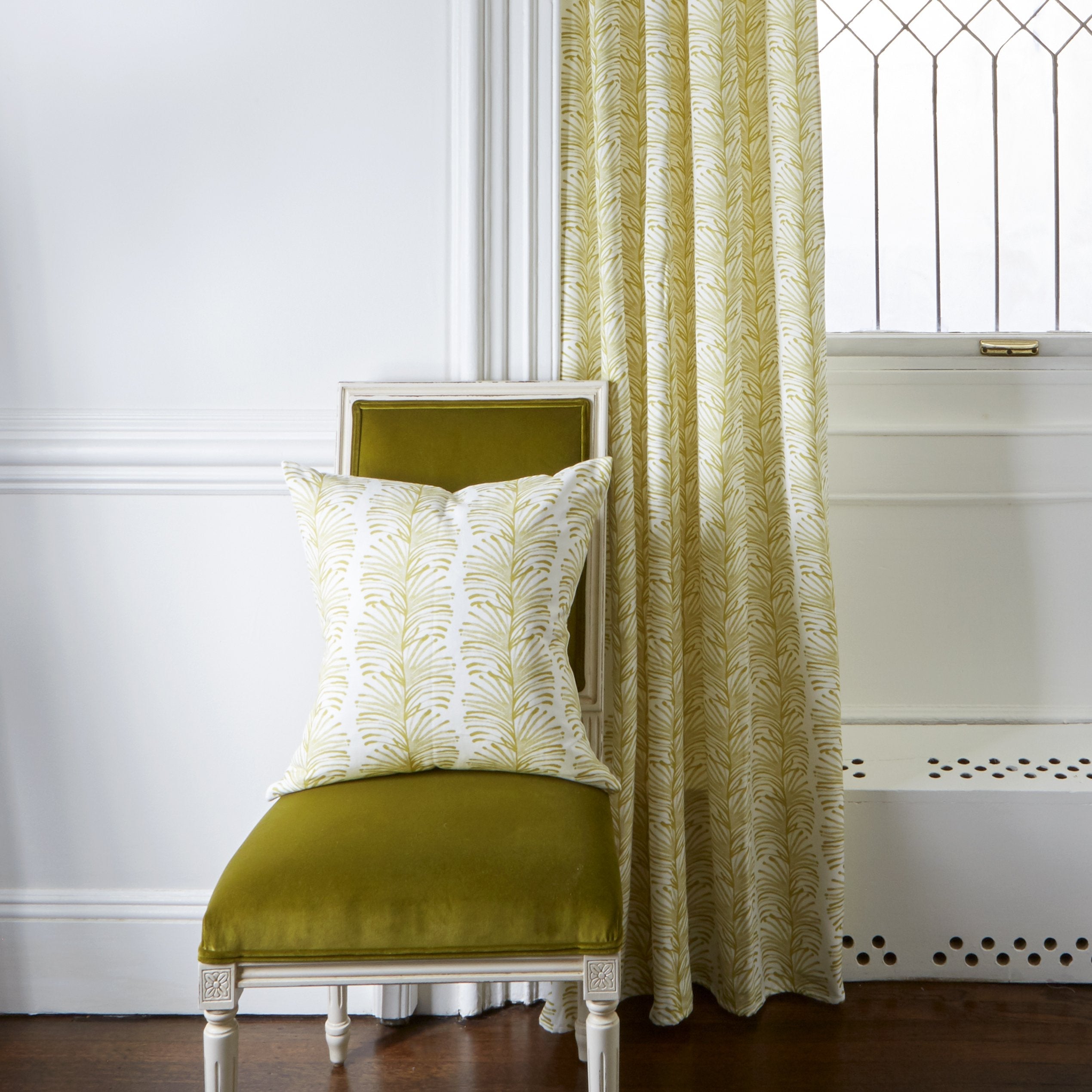 Yellow Stripe Chartreuse Pillow on Mustard Yellow Velvet Chair next to Yellow Stripe Chartreuse Printed Curtain by window
